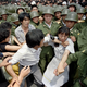 A young woman is caught between civilians and Chinese soldiers trying to remove her from an assembly near the Great Hall of the People in Beijing.